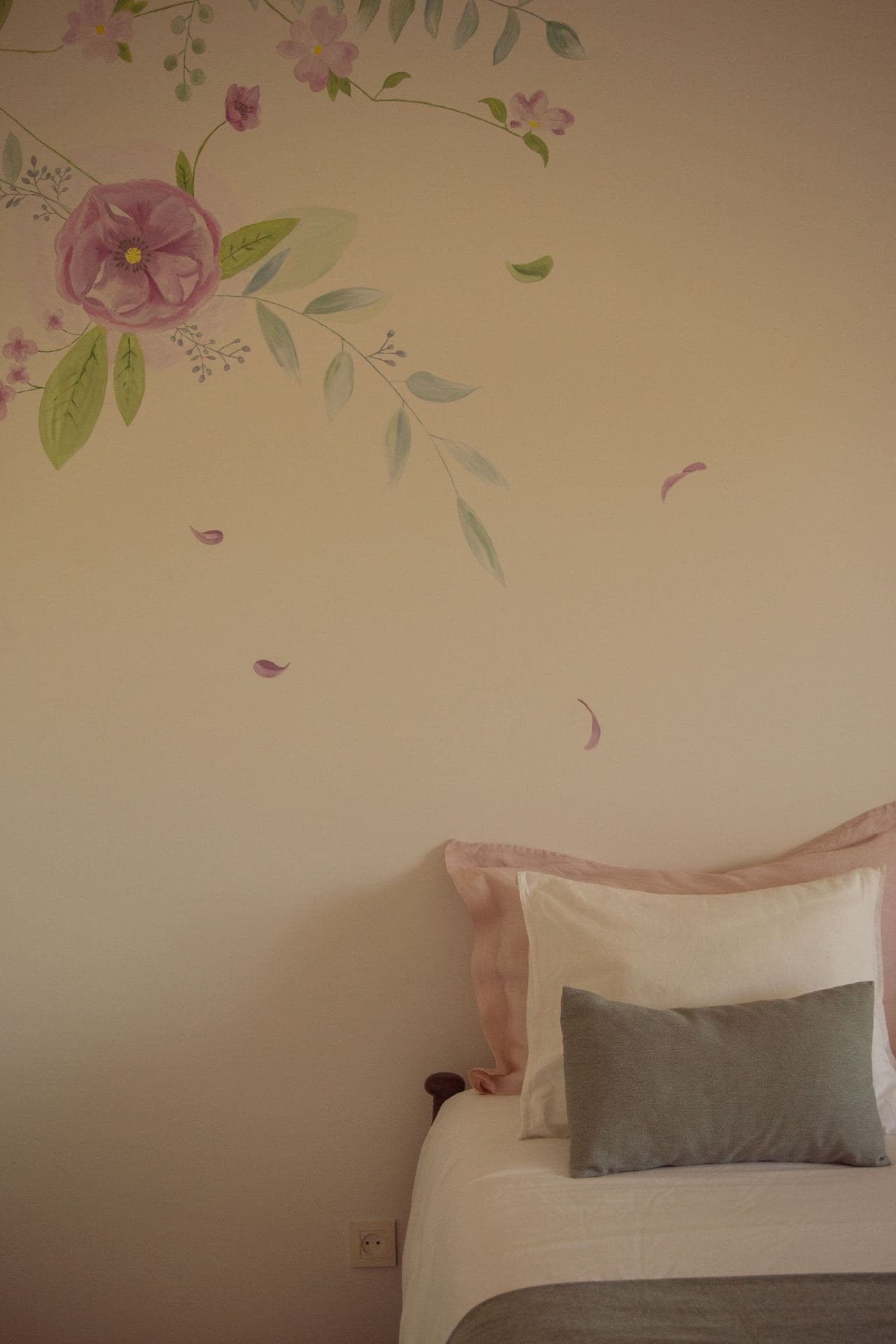 Floral wall mural above a bed